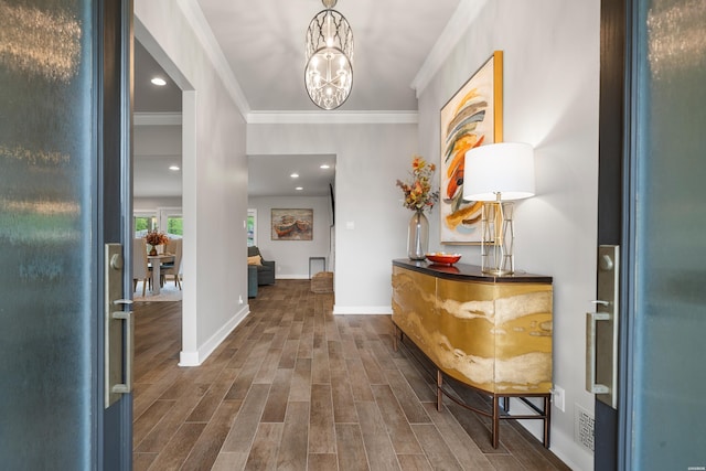 entrance foyer featuring dark wood-style floors, recessed lighting, a notable chandelier, crown molding, and baseboards