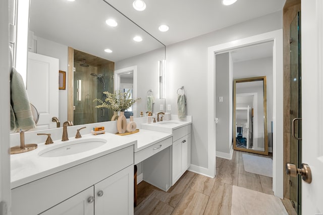 full bathroom featuring recessed lighting, a stall shower, double vanity, and a sink