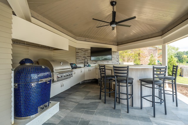 view of patio with ceiling fan, area for grilling, and outdoor wet bar