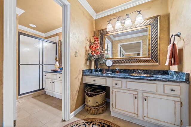 full bathroom with a stall shower, crown molding, vanity, and tile patterned floors