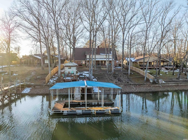 view of dock featuring a water view, boat lift, and a residential view