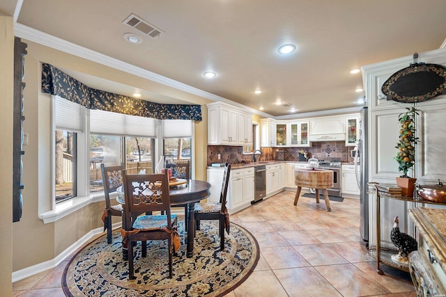 dining area with light tile patterned floors, baseboards, visible vents, ornamental molding, and recessed lighting