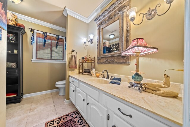 bathroom featuring crown molding, toilet, vanity, tile patterned flooring, and baseboards