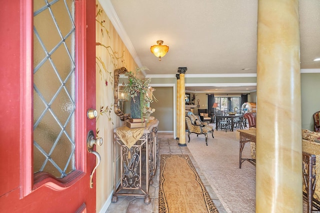 carpeted entrance foyer featuring ornate columns and crown molding