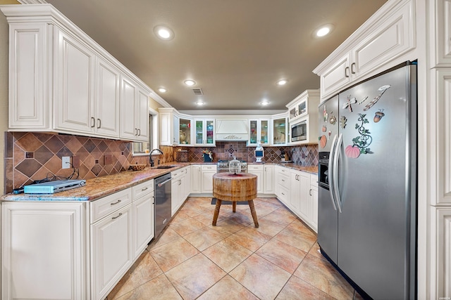 kitchen featuring white cabinets, light stone countertops, glass insert cabinets, and stainless steel appliances