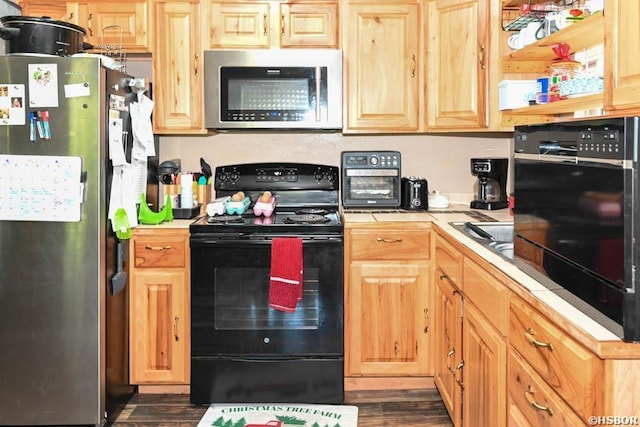 142 Taylor Loop, Oden, AR 71961 - kitchen featuring appliances with stainless steel finishes, tile countertops, dark wood-type flooring, and light brown cabinetry