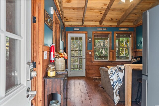 doorway featuring vaulted ceiling with beams, dark wood-type flooring, wooden ceiling, and a wealth of natural light