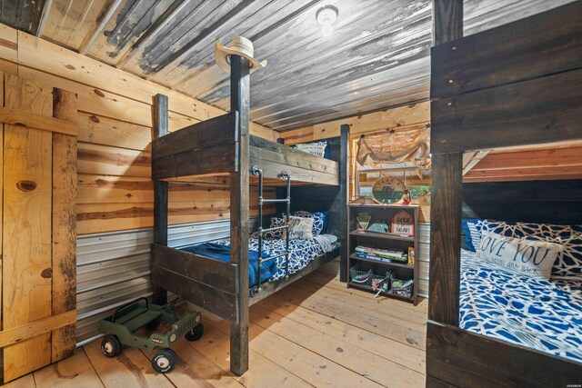 bedroom featuring wood ceiling, wood walls, and wood finished floors