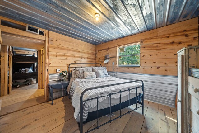 bedroom with wood ceiling, wooden walls, and wood finished floors