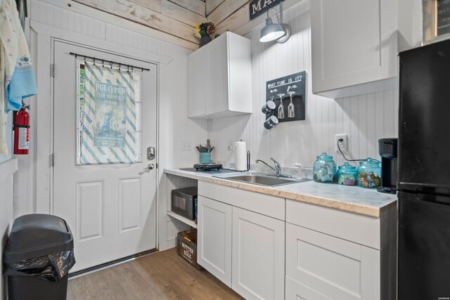 kitchen with black appliances, light countertops, and white cabinets