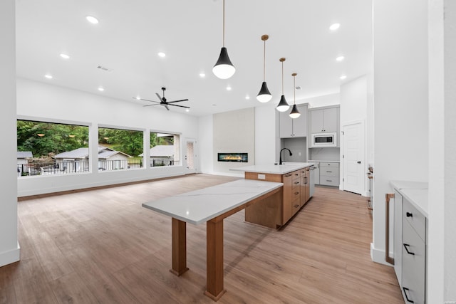 168 Krause Ln Unit A & B, Hot Springs, AR 71913 - kitchen featuring white microwave, a large fireplace, ceiling fan, a center island with sink, and recessed lighting