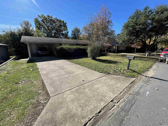 ranch-style house featuring driveway, a front lawn, and an attached carport