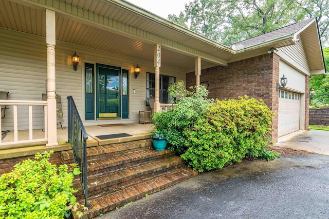 204 Paradise Pt, Hot Springs, AR 71913 - property entrance with covered porch, concrete driveway, brick siding, and an attached garage