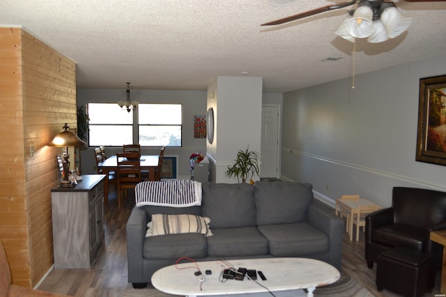 living area featuring a ceiling fan, a textured ceiling, visible vents, and wood finished floors