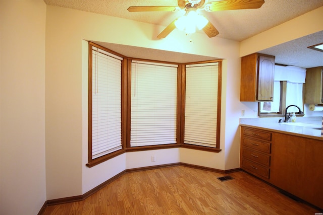 1 Alora Ln, Hot Springs Village, AR 71909 - kitchen featuring visible vents, brown cabinets, light countertops, a textured ceiling, and a sink