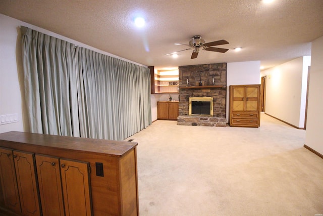 1 Alora Ln, Hot Springs Village, AR 71909 - living room featuring a ceiling fan, light colored carpet, a textured ceiling, and a stone fireplace