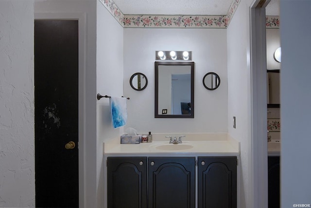 bathroom featuring a textured ceiling and vanity