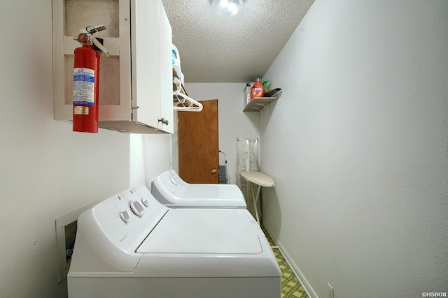 laundry room with cabinet space, baseboards, tile patterned floors, a textured ceiling, and washing machine and dryer