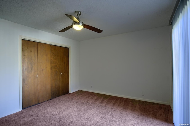 unfurnished bedroom featuring carpet floors, a closet, ceiling fan, a textured ceiling, and baseboards