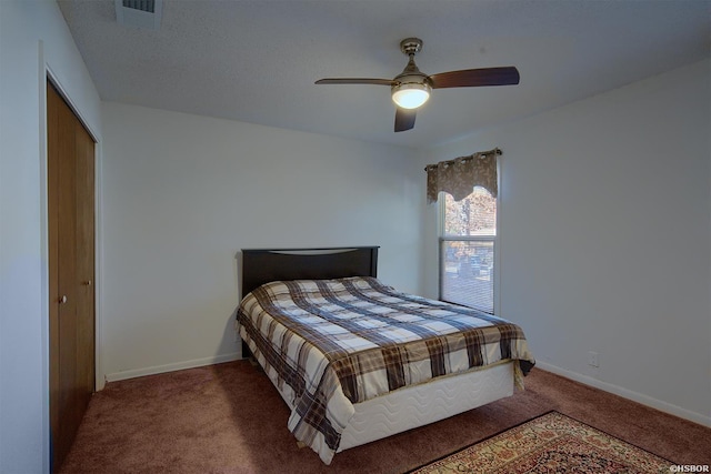 carpeted bedroom with ceiling fan, a closet, visible vents, and baseboards