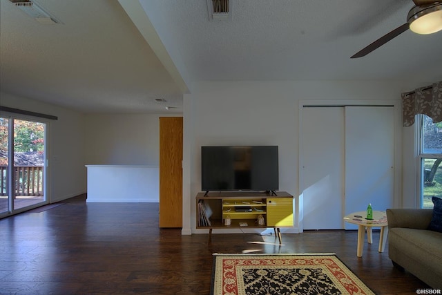 living area featuring a ceiling fan, visible vents, and wood finished floors