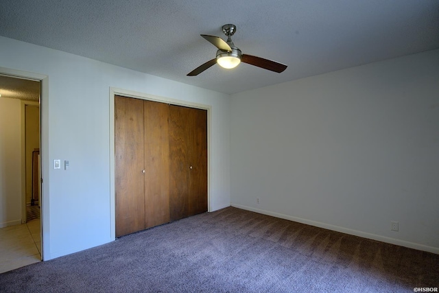 unfurnished bedroom with a closet, a ceiling fan, light carpet, a textured ceiling, and baseboards