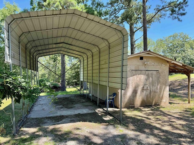 view of parking with a carport and a storage unit