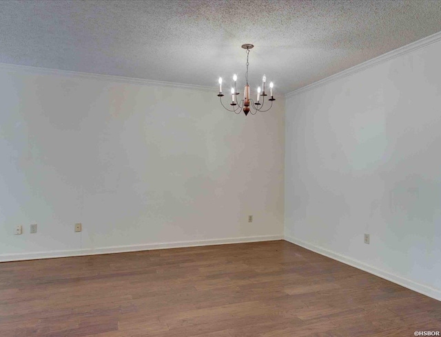 unfurnished room with a notable chandelier, a textured ceiling, ornamental molding, and dark wood-type flooring