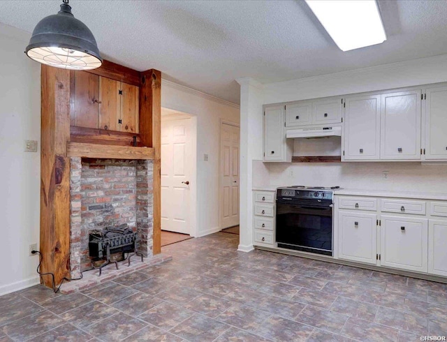 kitchen with under cabinet range hood, hanging light fixtures, light countertops, range, and a wood stove