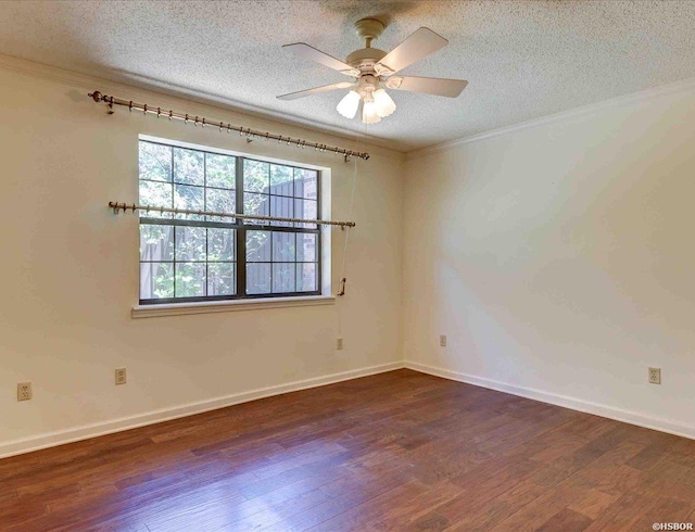 spare room featuring dark wood-style flooring, a ceiling fan, ornamental molding, a textured ceiling, and baseboards