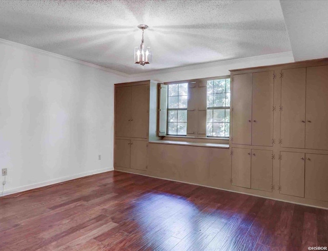 unfurnished room with dark wood-style floors, baseboards, ornamental molding, and a textured ceiling