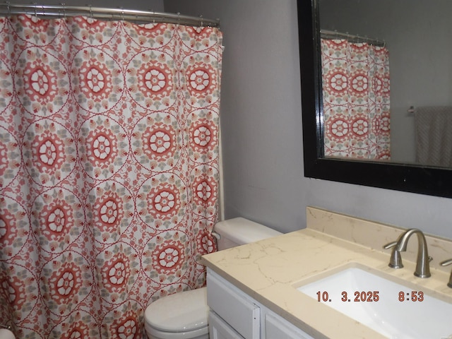 full bathroom with curtained shower, toilet, and vanity