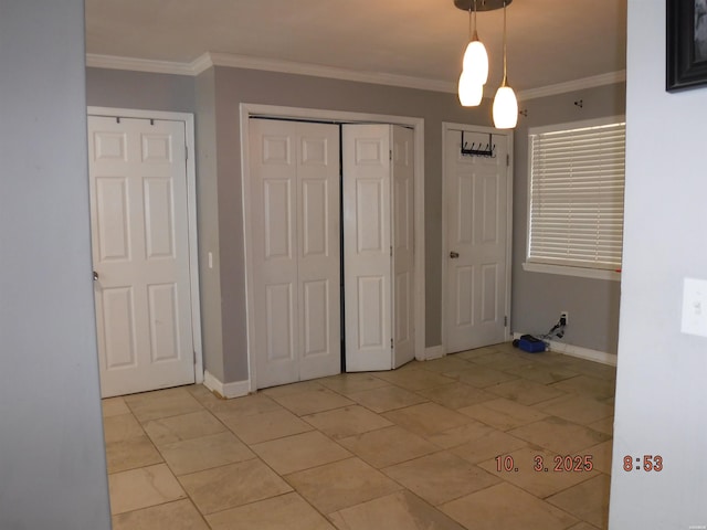 unfurnished bedroom with a closet, crown molding, and baseboards