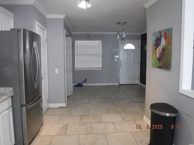 interior space with light tile patterned flooring, baseboards, and ornamental molding