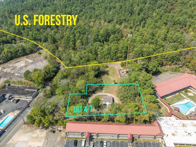 birds eye view of property featuring a forest view