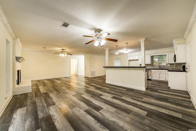 221 San Juan Dr, Hot Springs, AR 71913 - unfurnished living room featuring ceiling fan, ornate columns, dark wood-style floors, crown molding, and a brick fireplace