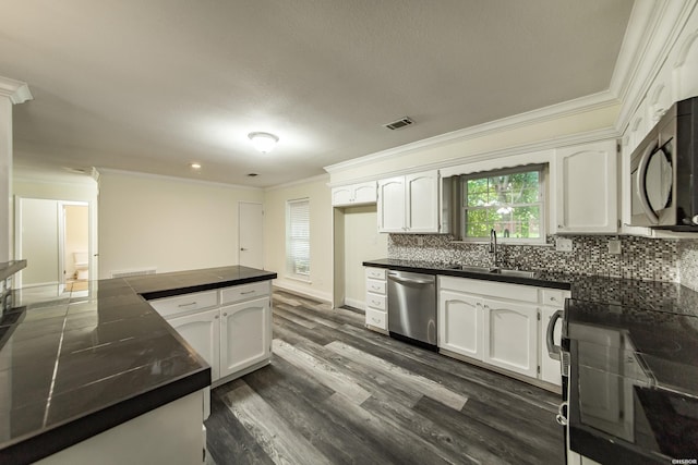 221 San Juan Dr, Hot Springs, AR 71913 - kitchen featuring stainless steel appliances, ornamental molding, dark countertops, and white cabinets