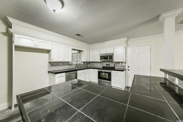 221 San Juan Dr, Hot Springs, AR 71913 - kitchen with appliances with stainless steel finishes, white cabinets, crown molding, backsplash, and a textured ceiling