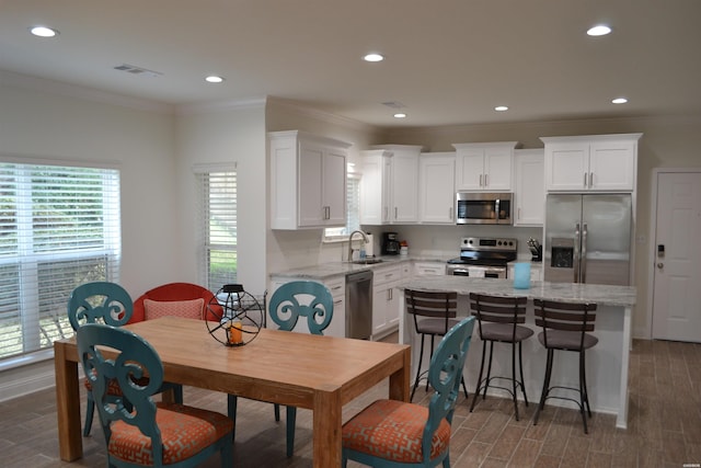 dining space with ornamental molding, dark wood finished floors, visible vents, and recessed lighting