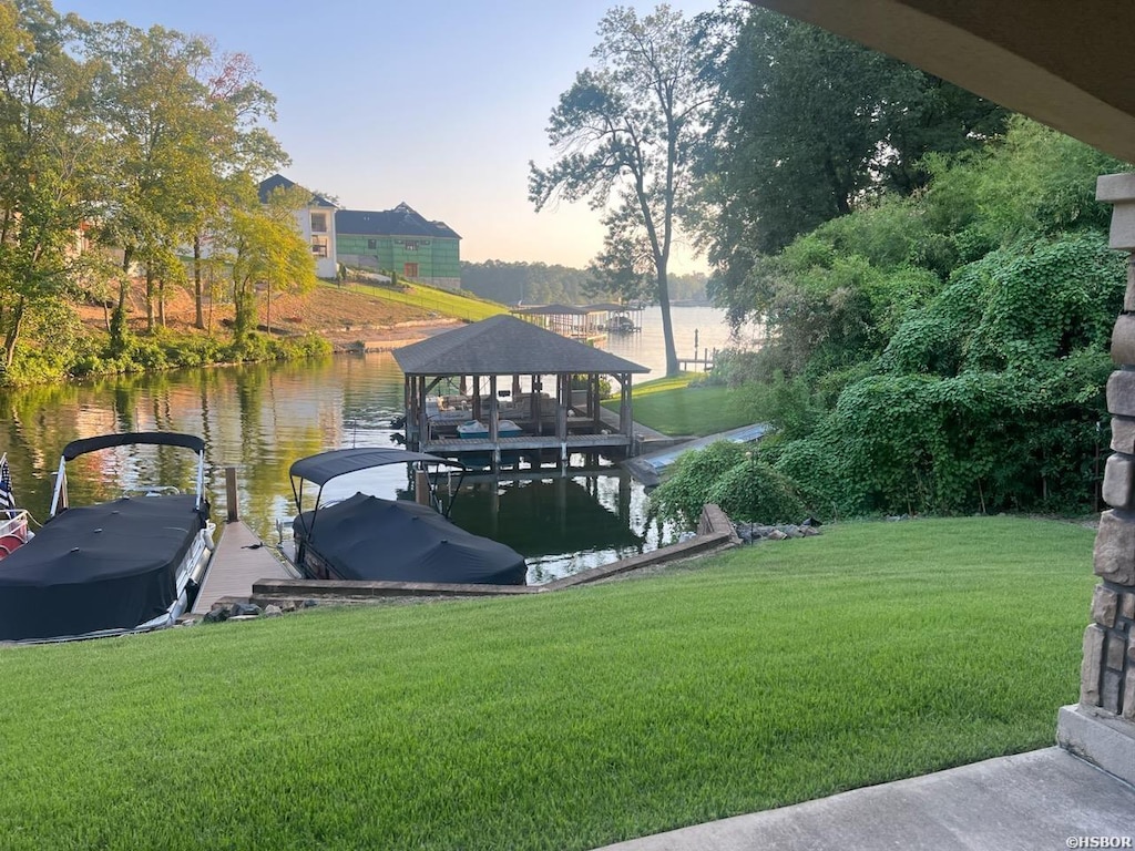 view of dock featuring a water view and a yard