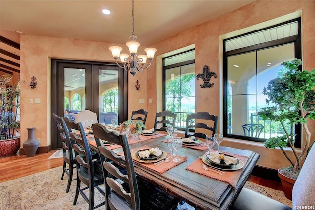 dining space with wood finished floors and a chandelier