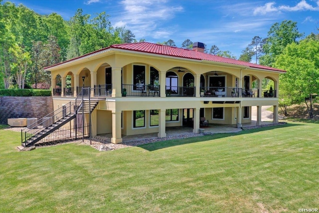 back of property featuring a chimney, stairway, a patio area, and a lawn