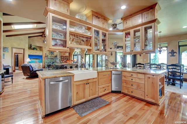 kitchen with a sink, stainless steel dishwasher, light brown cabinets, beamed ceiling, and light wood-style floors