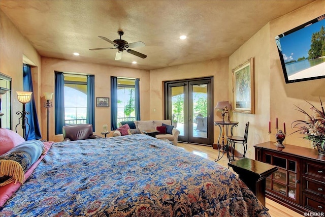 bedroom featuring french doors, a textured ceiling, access to outside, light wood-style floors, and recessed lighting