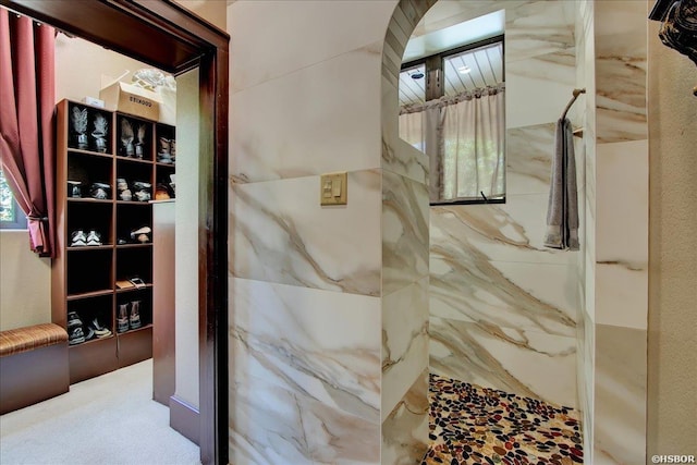 bathroom featuring a marble finish shower