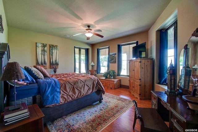 bedroom featuring light wood-type flooring, visible vents, and a ceiling fan