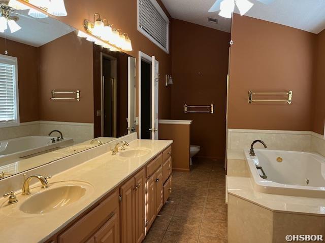 full bath with a sink, a ceiling fan, and tile patterned floors