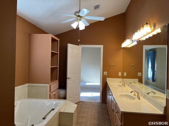 full bath featuring a sink, lofted ceiling, ceiling fan, and tile patterned flooring