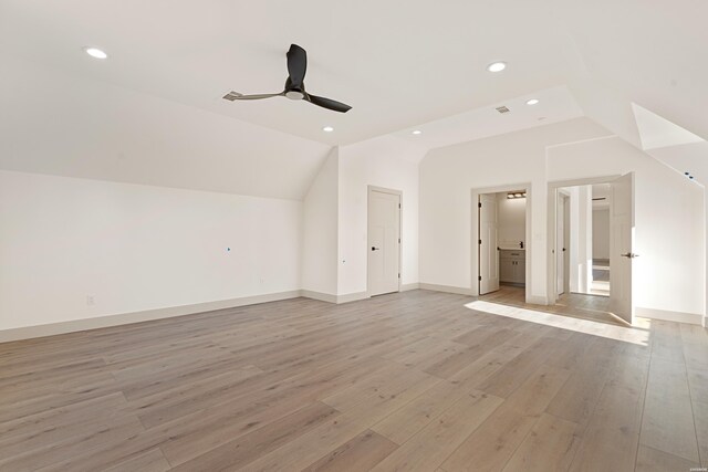 bonus room featuring light wood finished floors, ceiling fan, baseboards, and vaulted ceiling