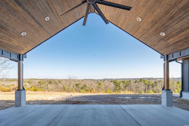 view of patio with a forest view and a ceiling fan